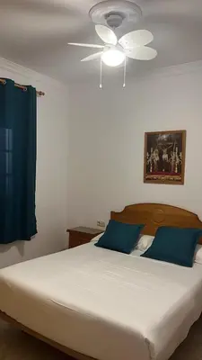 a bedroom with a large bed with a ceiling fan at VILLA LA MOMITA in Chiclana de la Frontera