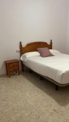 a bedroom with a bed and a nightstand next to a bedsenalsenalsenal at VILLA LA MOMITA in Chiclana de la Frontera