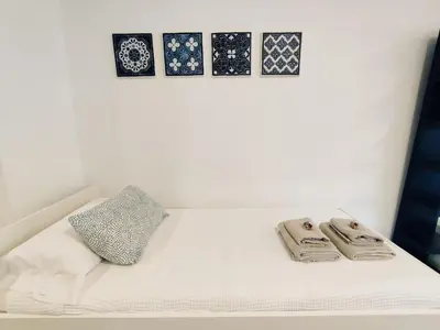 a white bed with two towels and a pillow at Loft Paseo Marítimo in Cádiz