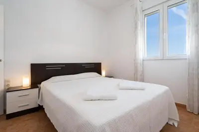 a bedroom with a white bed with two towels on it at Apartoyou - Fuentebravía Playa in El Puerto de Santa María