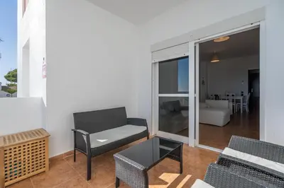 a living room with a couch and a chair and a table at Apartoyou - Fuentebravía Playa in El Puerto de Santa María