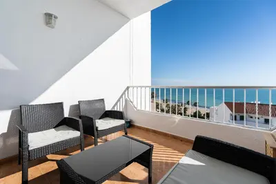 a balcony with chairs and a view of the ocean at Apartoyou - Fuentebravía Playa in El Puerto de Santa María
