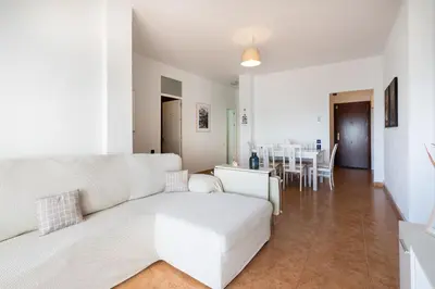 a living room with a white couch and a table at Apartoyou - Fuentebravía Playa in El Puerto de Santa María