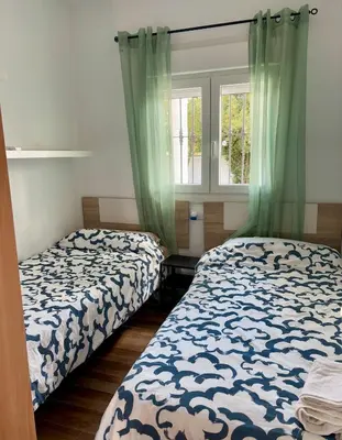 a bedroom with two beds and a window at Fantástico chalet con piscina 2 km de la barrosa in Chiclana de la Frontera