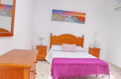 a bedroom with a bed with a pink blanket at Chalet Blue in Conil de la Frontera