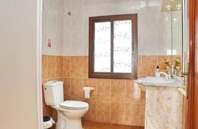 a bathroom with a toilet and a sink and a window at Chalet Blue in Conil de la Frontera