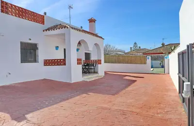 a white house with a red brick patio at Chalet Blue in Conil de la Frontera