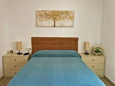 a bedroom with a bed and two dressers with lamps at Apartamento Alván - Ole Solutions in Jerez de la Frontera