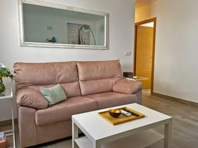 a living room with a brown couch and a table at Apartamento Alván - Ole Solutions in Jerez de la Frontera