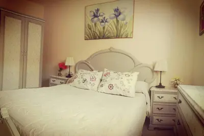 a bedroom with a white bed with pillows and two lamps at Centro Sanlúcar Barrameda/Cuesta Ganado in Sanlúcar de Barrameda