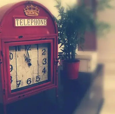 a red clock sitting next to a potted plant at Centro Sanlúcar Barrameda/Cuesta Ganado in Sanlúcar de Barrameda