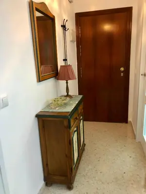 a lamp on top of a wooden cabinet in a hallway at Sol y playa Sanlúcar in Sanlúcar de Barrameda