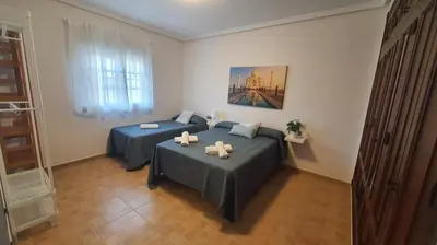 a bedroom with two beds and a window at LOS ALMENDROS in Chiclana de la Frontera