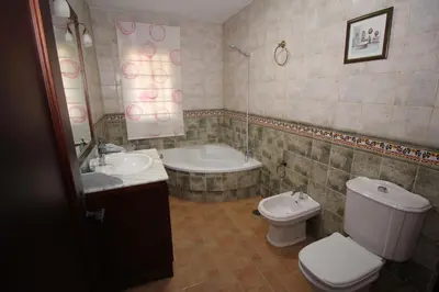 a bathroom with a toilet and a sink and a tub at LOS ALMENDROS in Chiclana de la Frontera