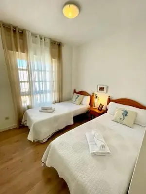 a hotel room with two beds and a window at GATU PREMIUM Villa Poniente, junto la playa de Valdelagrana 