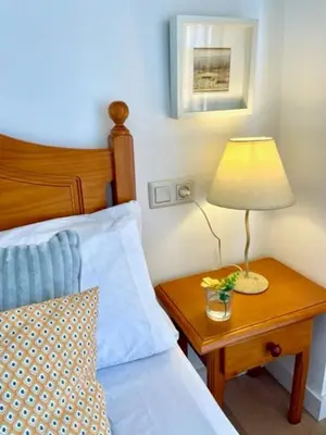 a bedroom with a bed and a table with a lamp at GATU PREMIUM Villa Poniente, junto la playa de Valdelagrana 
