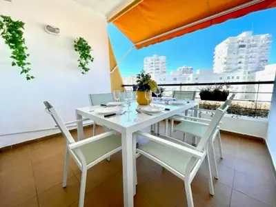 a white table and chairs on a balcony with a view at GATU PREMIUM Villa Poniente, junto la playa de Valdelagrana 