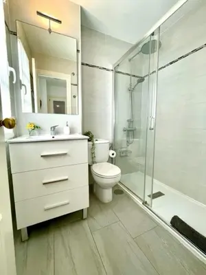 a bathroom with a toilet and a glass shower at GATU PREMIUM Villa Poniente, junto la playa de Valdelagrana 