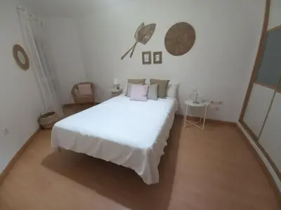 a white bedroom with a large white bed and a table at Cantabrico playa Grupo AC Gestion in Cádiz
