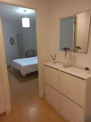 a bathroom with a dresser with a mirror and a bed at Cantabrico playa Grupo AC Gestion in Cádiz