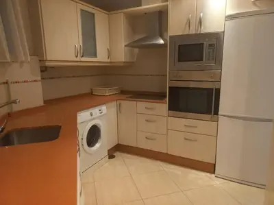 a kitchen with a washing machine and a microwave at Cantabrico playa Grupo AC Gestion in Cádiz
