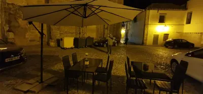 a table with an umbrella on a street at night at Azafran Jerez estudio in Jerez de la Frontera