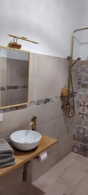 a bathroom with a sink and a mirror and a shower at Azafran Jerez estudio in Jerez de la Frontera