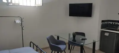 a room with a glass table and a television on a wall at Azafran Jerez estudio in Jerez de la Frontera