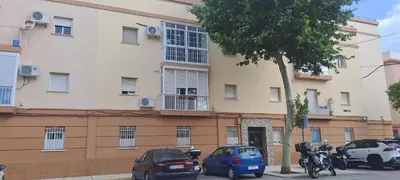 a building with cars parked in front of it at Playas, cultura y gastronomía en Casa Sarco 2 habitaciones in San Fernando