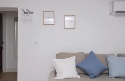 a living room with a couch with blue and white pillows at En el mismo Centro - Aires del Puerto in El Puerto de Santa María