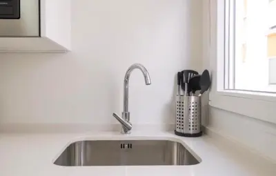 a stainless steel kitchen sink in a white kitchen at En el mismo Centro - Aires del Puerto in El Puerto de Santa María