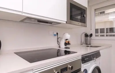 a white kitchen with a sink and a washing machine at En el mismo Centro - Aires del Puerto in El Puerto de Santa María