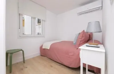 a bedroom with a bed and a desk with a lamp at En el mismo Centro - Aires del Puerto in El Puerto de Santa María