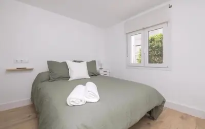 a bedroom with a bed with two towels on it at En el mismo Centro - Aires del Puerto in El Puerto de Santa María