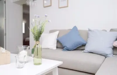 a vase with flowers on a table in a living room at En el mismo Centro - Aires del Puerto in El Puerto de Santa María