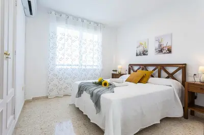 a white bedroom with two beds and a window at Luminoso 3 rooms 2 Baños Parking in Jerez de la Frontera