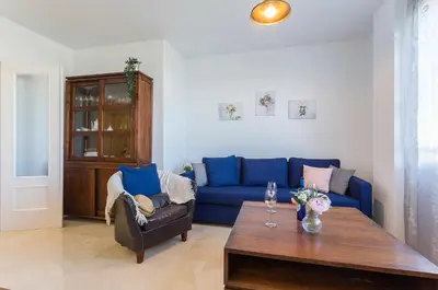 a living room with a blue couch and a table at Luminoso 3 rooms 2 Baños Parking in Jerez de la Frontera