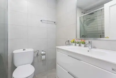 a white bathroom with a toilet and a sink at Luminoso 3 rooms 2 Baños Parking in Jerez de la Frontera