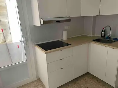 a kitchen with white cabinets and a sink and a window at Casa del mar in San Fernando