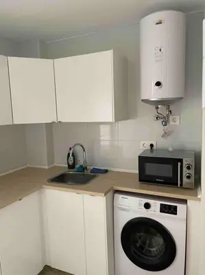 a kitchen with a washing machine and a microwave at Casa del mar in San Fernando