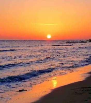 a sunset on the beach with the sun setting in the ocean at Casa del mar in San Fernando