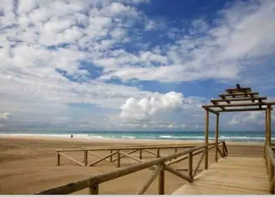 a wooden boardwalk on a beach with the ocean at Casa del mar in San Fernando