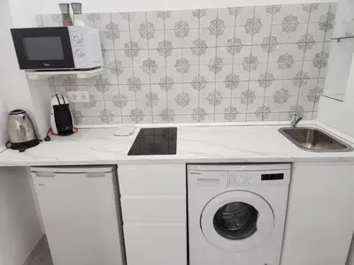 a kitchen with a washing machine and a microwave at Allo Apartments 