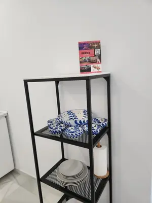 a black shelf with blue and white dishes on it at Allo Apartments 