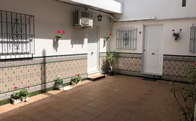 a courtyard with potted plants and a white door at Allo Apartments 