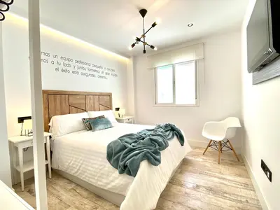 a white bedroom with a bed and a television at People Homes Ponce 13 in Jerez de la Frontera