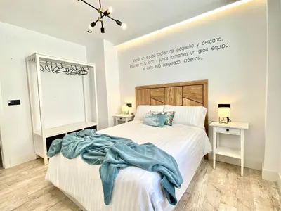 a bedroom with a bed with a blue blanket on it at People Homes Ponce 13 in Jerez de la Frontera