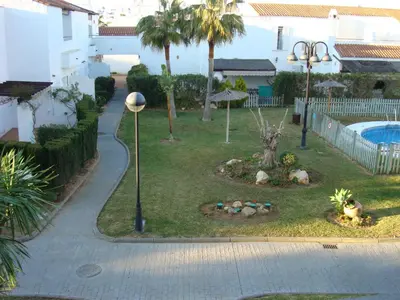 a street light next to a yard with a pool at Apartamento residencial de golf y playa Cadiz in Rota