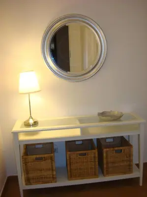 a table with baskets and a lamp and a mirror at Apartamento residencial de golf y playa Cadiz in Rota