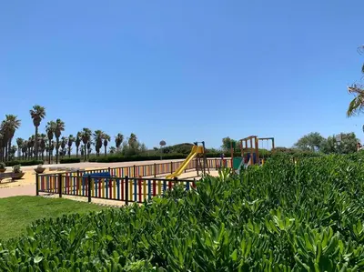 a park with a playground with a slide at Apartamento residencial de golf y playa Cadiz in Rota